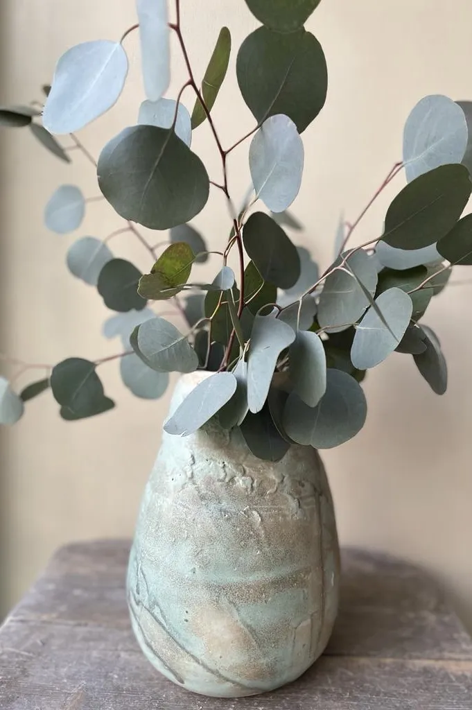 Handgetöpferte Vase mit Eukalyptuszweigen